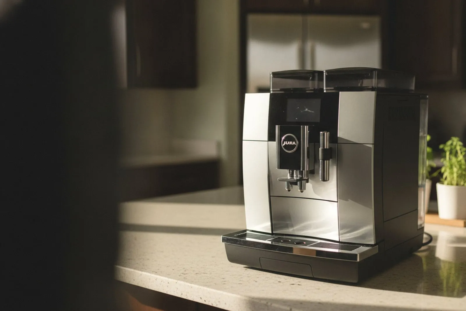 Jura super-automatic espresso machine alone on a kitchen counter, three-quarter view, JURA logo on the front