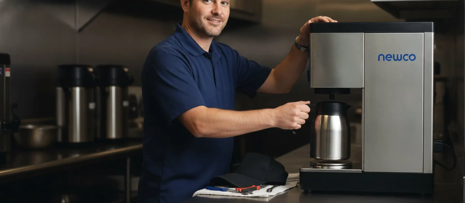 Newco AK-LD batch brewer on a restaurant service counter, technician at the brew basket